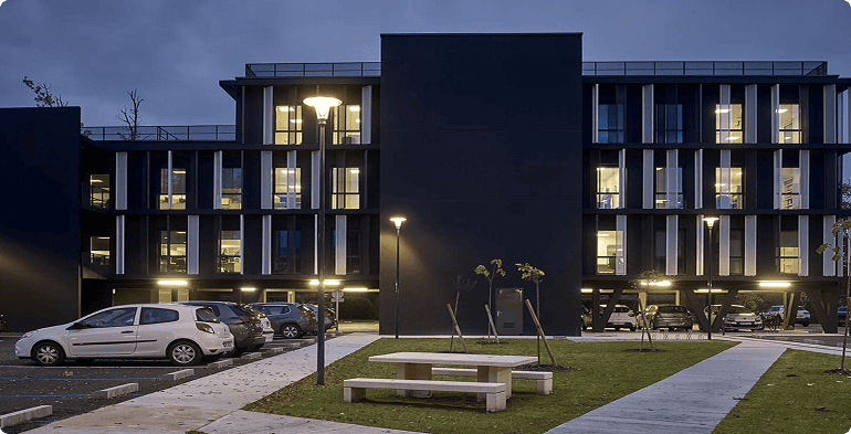 Vue nocturne de l'immeuble de bureaux Link Park à Mérignac avec façades éclairées et espaces extérieurs aménagés, BMG Foncière.