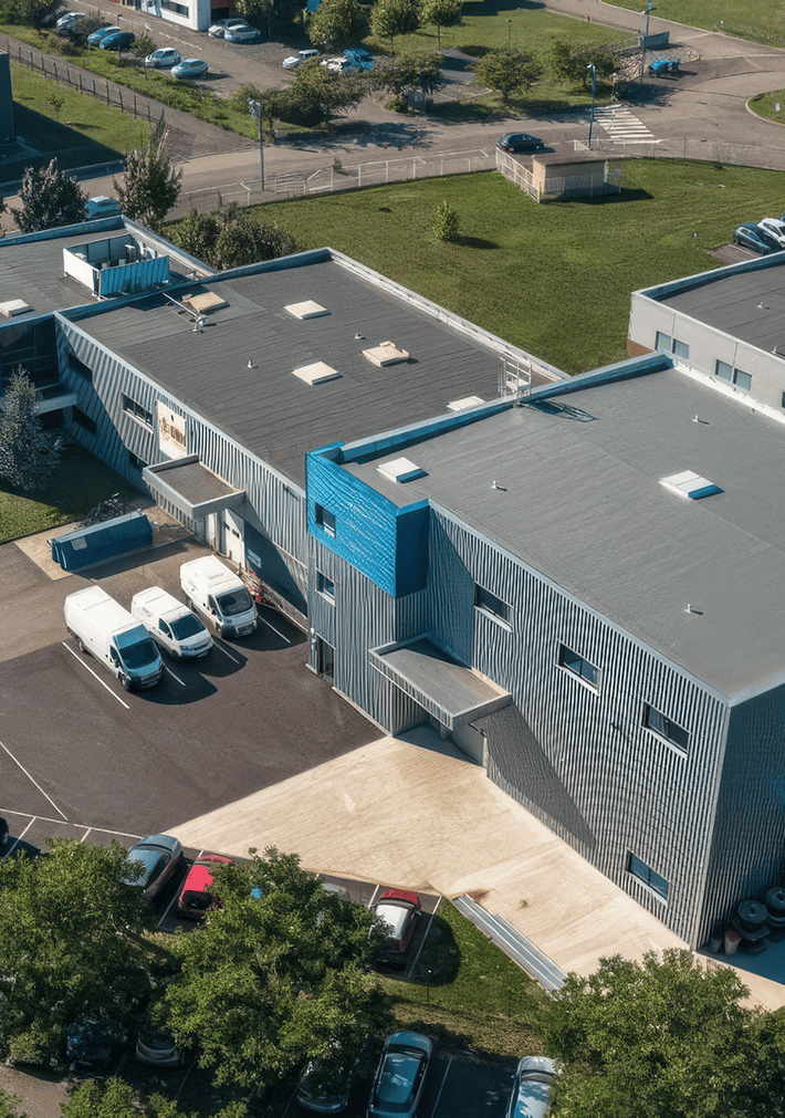 Vue aérienne d'un immeuble d'activités acquis par BMG Foncière à Entzheim, avec quais de livraison, parkings et bâtiments industriels, BMG Foncière.