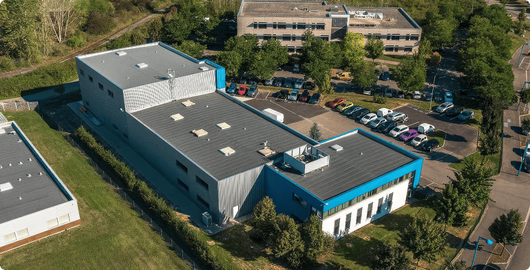 Vue aérienne arrière de l'immeuble d'activités d'Entzheim montrant les volumes du bâtiment, les espaces verts et les stationnements, BMG Foncière.