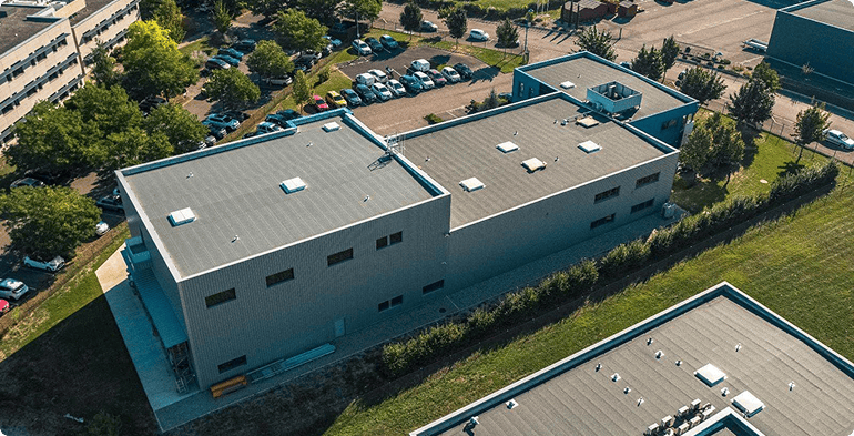Vue aérienne de la toiture et des façades de l'immeuble d'activités acquis à Entzheim avec emprises techniques et espaces extérieurs, BMG Foncière.