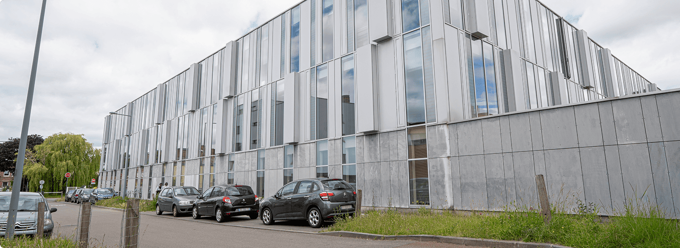 Vue latérale de l'immeuble de bureaux Reflet de Lille avec façades vitrées et stationnement en bordure de voirie, BMG Foncière, filiale du Groupe FSDV.