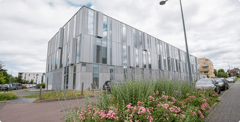 Vue générale de l'immeuble de bureaux Reflet de Lille avec massifs fleuris et façade contemporaine, BMG Foncière, filiale du Groupe FSDV.