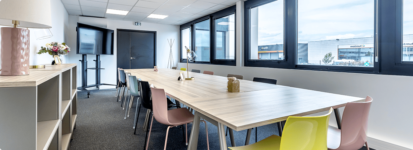 Salle de réunion du centre B'CoWorker au Mans avec grande table et écran de présentation, BMG Foncière, filiale du Groupe FSDV.