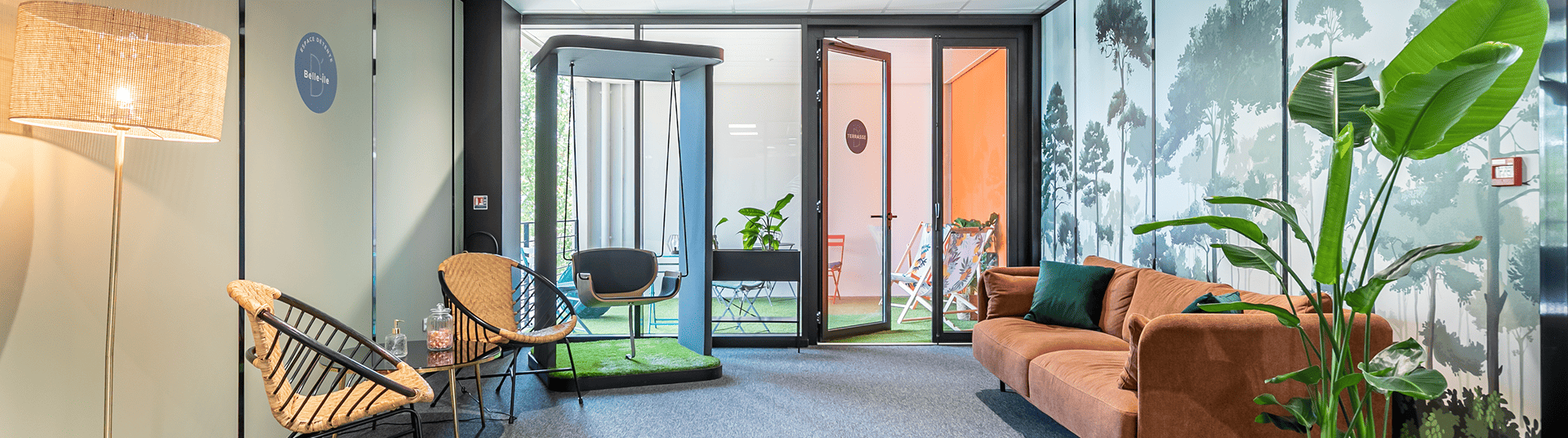 Espace détente et coworking de B'CoWorker Schiltigheim avec canapé, fauteuils, balançoire intérieure et accès à une terrasse.