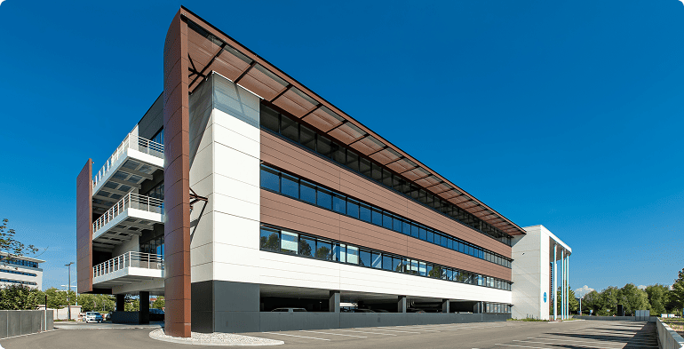 Vue d'ensemble de l'immeuble de bureaux Le Twins à Schiltigheim avec parking et façades contemporaines, BMG Foncière.
