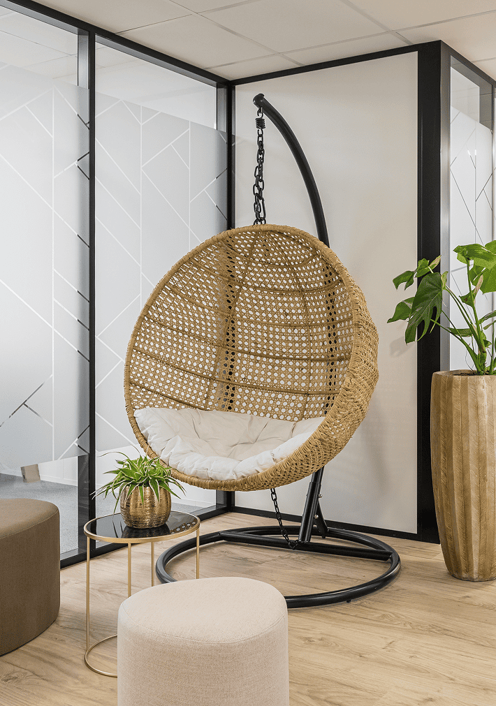 Fauteuil suspendu en rotin dans un espace détente du centre B’Coworker à Roubaix, avec cloisons vitrées et plantes, BMG Foncière.