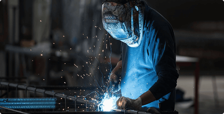 Soudeur réalisant l'assemblage d'armatures métalliques pour la préfabrication béton chez CIR PREFA.