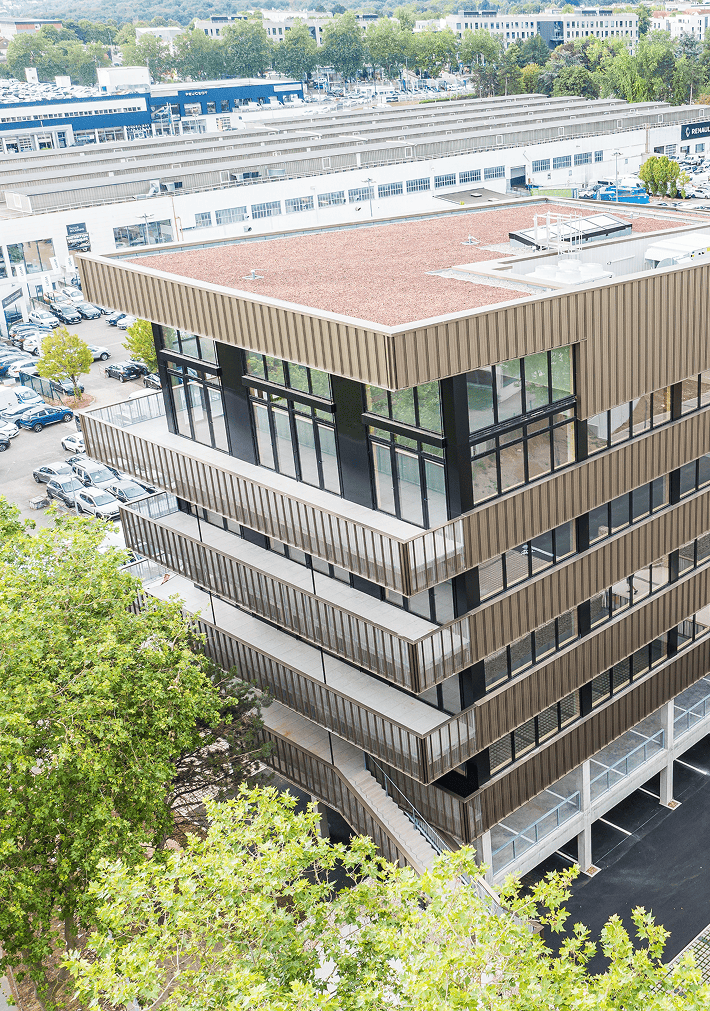 Vue aérienne du bâtiment Le Phénix à Laxou, avec façades vitrées, parking et environnement urbain, BMG Foncière.