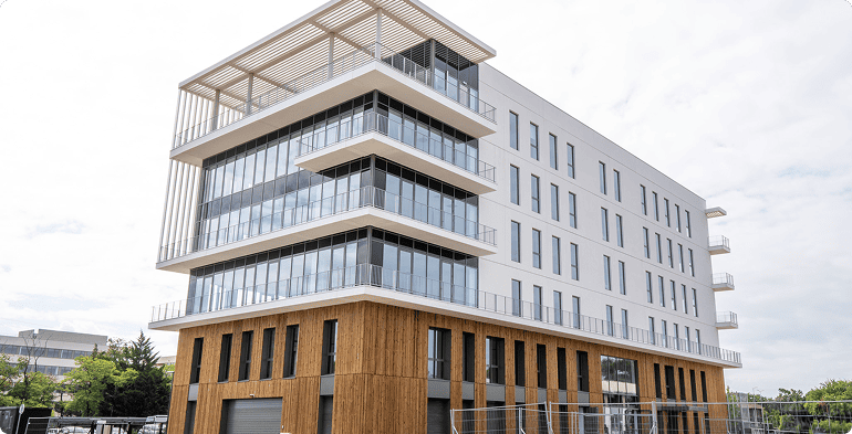 Perspective du bâtiment A du SPI à Mérignac avec balcons, façades vitrées et bardage bois, BMG Foncière.