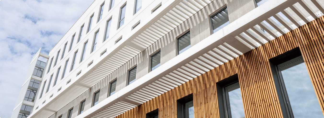 Façade du bâtiment A du SPI à Mérignac avec bardage bois, béton et protections solaires, BMG Foncière.