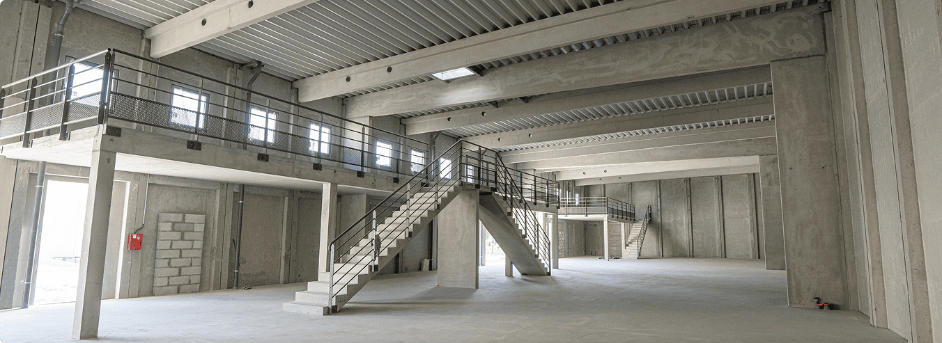 Volume intérieur d'un bâtiment d'activités du Parc de la Renardière aux Pennes-Mirabeau avec mezzanine, escalier central et grande hauteur sous plafond, BMG Foncière.