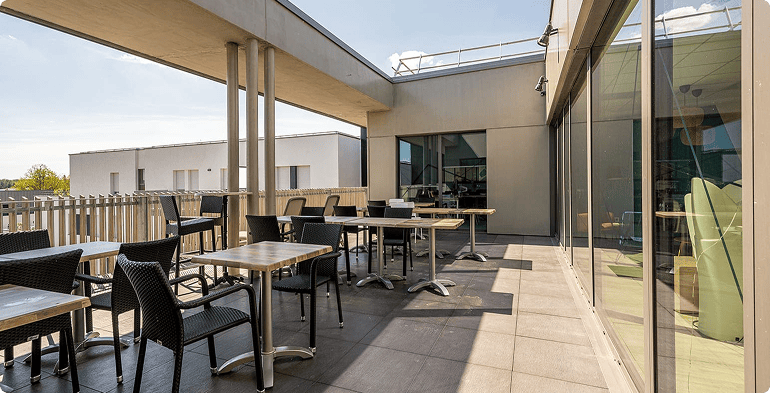 Vue d’un bâtiment à Valbonne, Sophia Antipolis, montrant une façade vitrée et les abords aménagés du site, BMG Foncière.